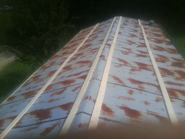 Rusted metal roof panels with new wood purlins before replacement — Storm Damage Roof Repair in Eva by Roofing Brothers