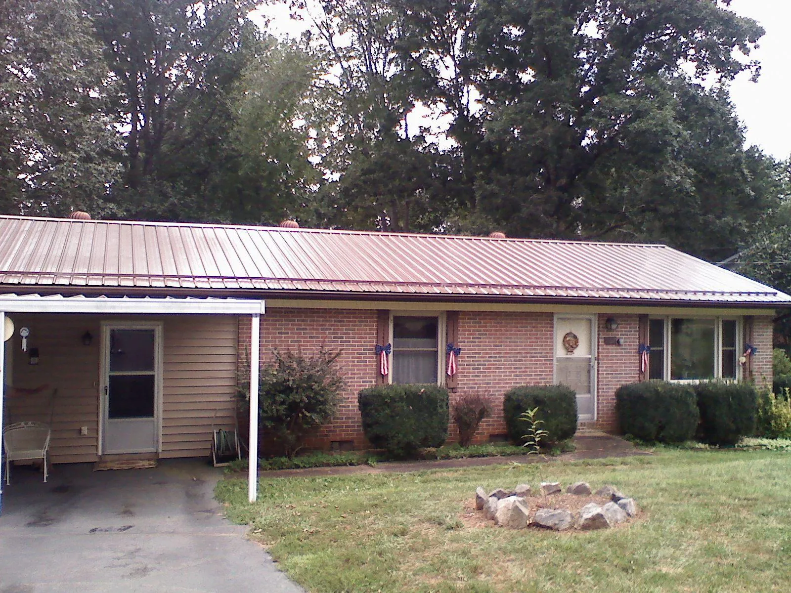 Bronze metal roof and carport on a brick ranch home — Roof Repair work by our crew in Eva